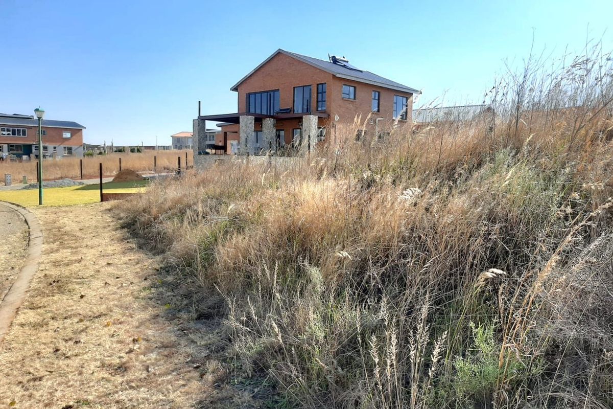 A view of the rear elevation of a double-story brick residential property featuring a covered patio and solar water heating system.