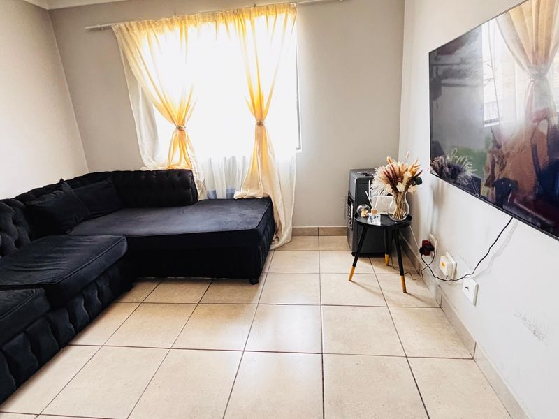 A living room featuring ceramic floor tiles and neutral wall finishes, providing a functional space for relaxation.