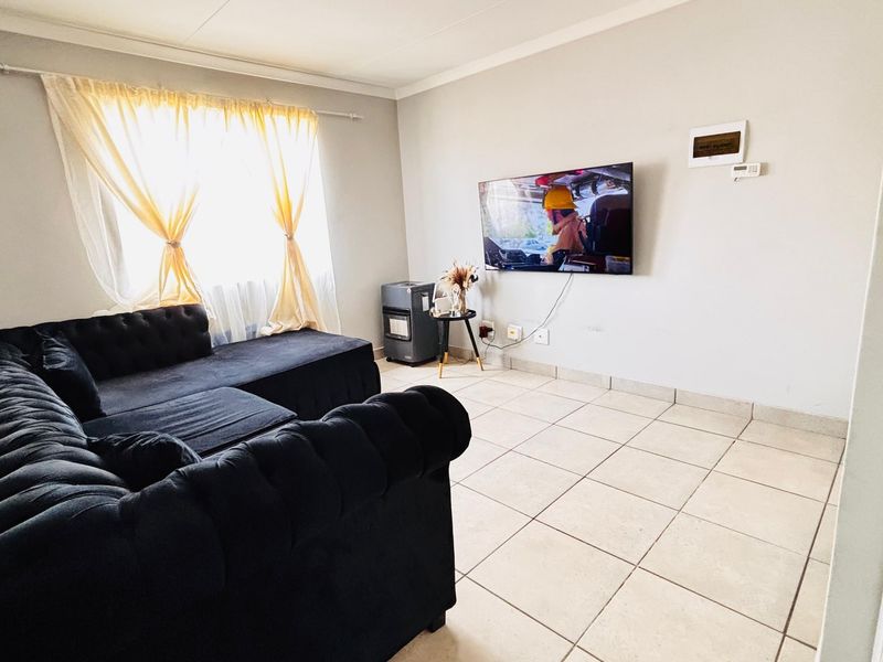A living room featuring tiled flooring and neutral wall finishes, providing a functional space for relaxation.