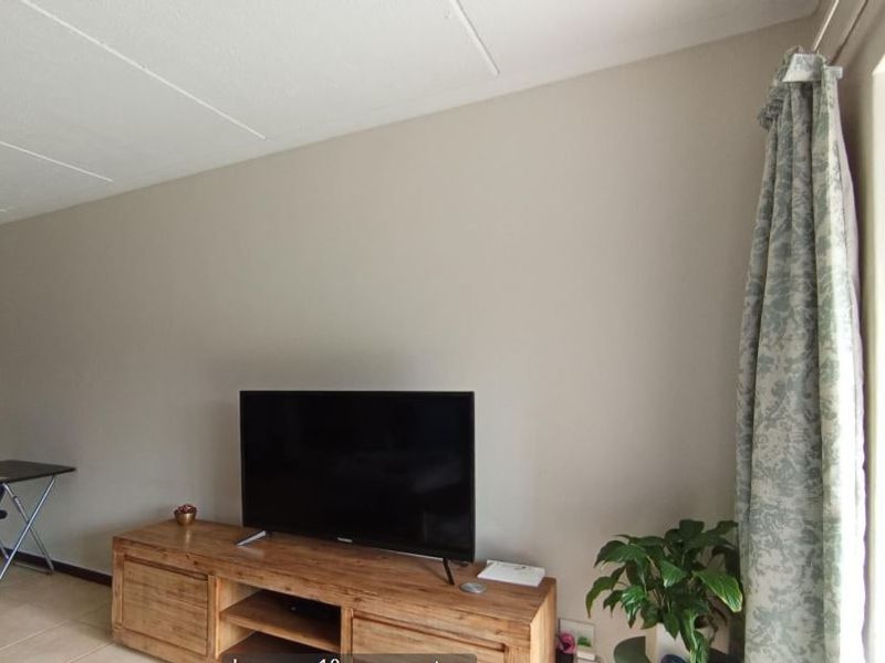 A living room area featuring tiled flooring and a sliding glass door providing access to the exterior.