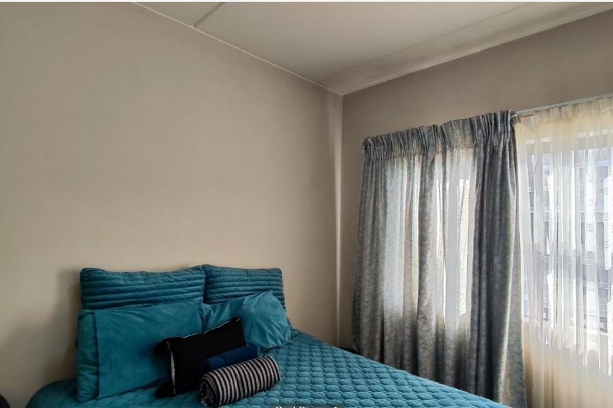 A bedroom featuring neutral wall finishes and a window with curtain tracks.