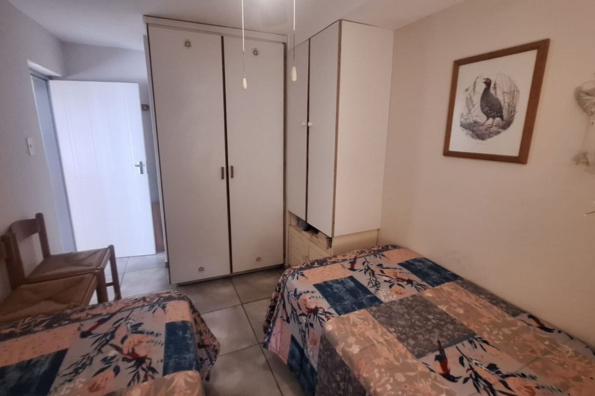 A bedroom featuring built-in cupboards and tiled flooring, providing functional storage space.