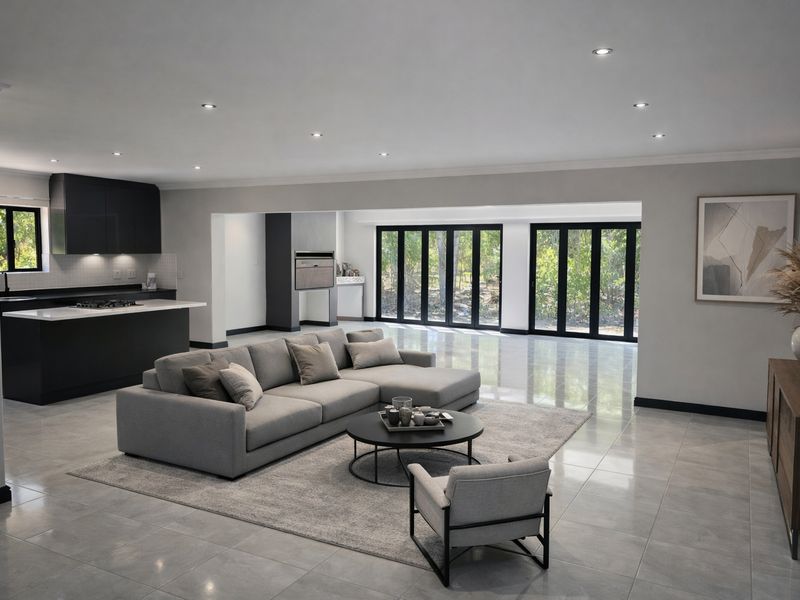 Spacious open-plan living area featuring a modern kitchen with island, sleek cabinetry, tiled floors, and large folding doors opening to the garden.