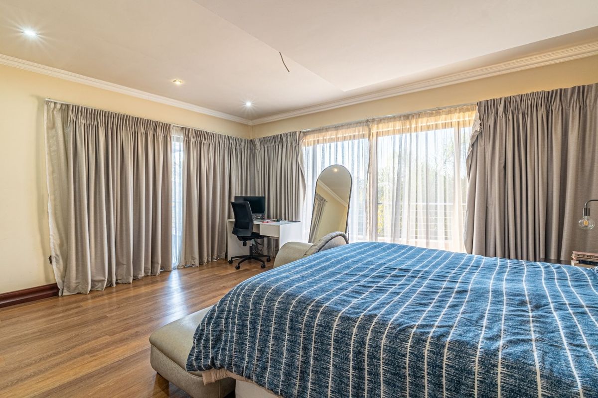 Spacious bedroom featuring laminate flooring, recessed downlighting, and large sliding glass doors that provide ample natural light and access to the exterior.