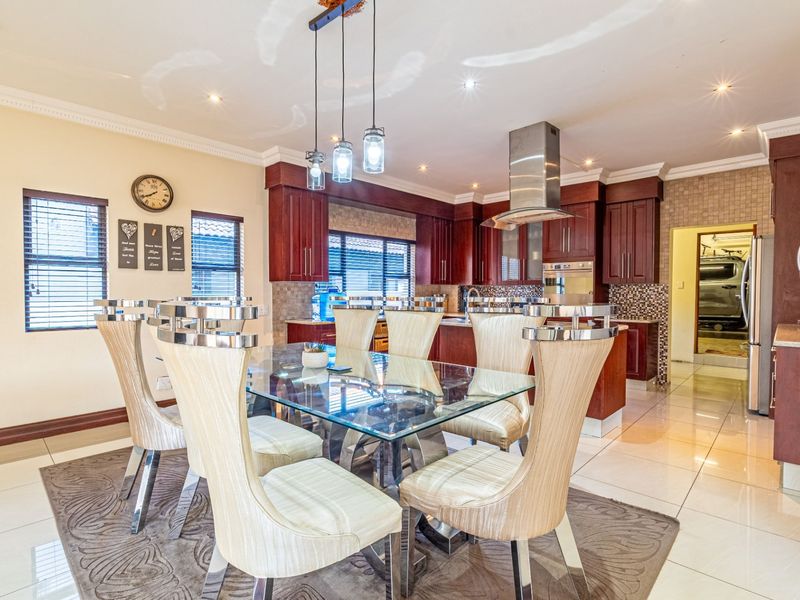 Open plan kitchen and dining area featuring cherry wood cabinetry, granite countertops, stainless steel appliances, and tiled flooring throughout.