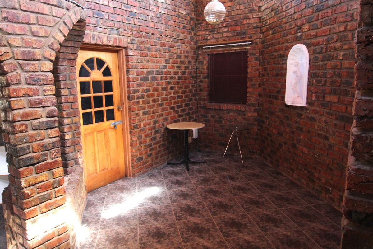 A unique interior space featuring exposed face-brick walls, high timber-clad ceilings, and tiled flooring, creating a rustic and character-filled atmosphere.