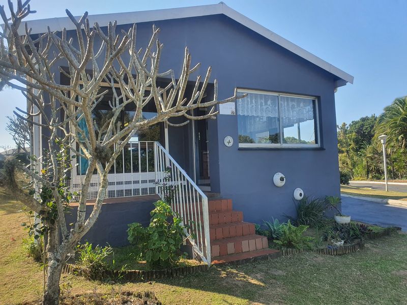 Front elevation of a townhouse featuring a tiled entrance staircase, metal security railing, and blue exterior wall finish.