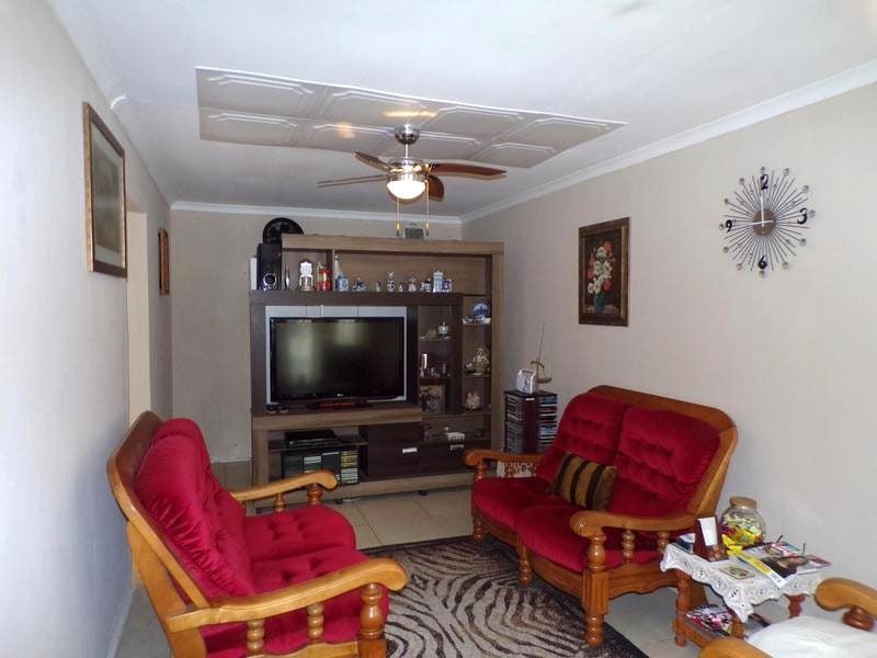 A living room featuring a ceiling fan and coving, providing a functional space for relaxation and entertainment.
