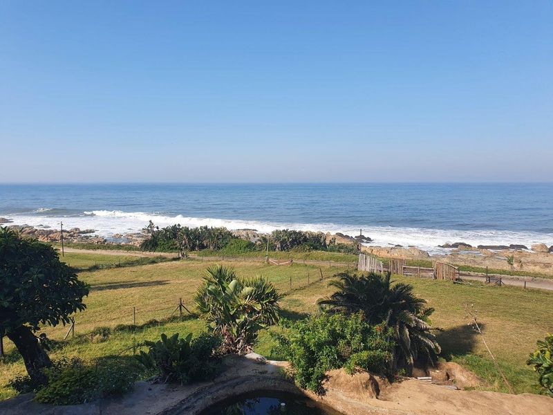 A scenic elevated view overlooking the coastline, featuring expansive ocean vistas and natural coastal vegetation.