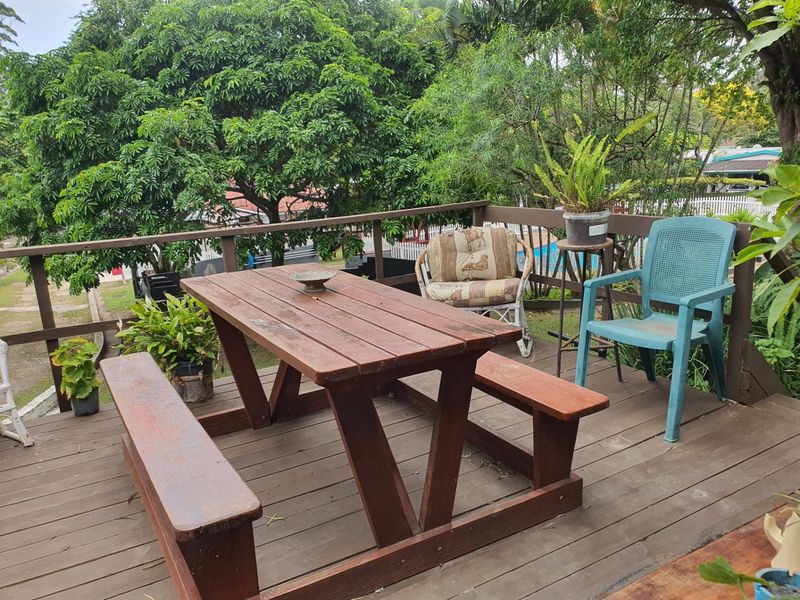 An elevated timber deck patio area featuring wooden railings, providing an outdoor space for relaxation and dining.