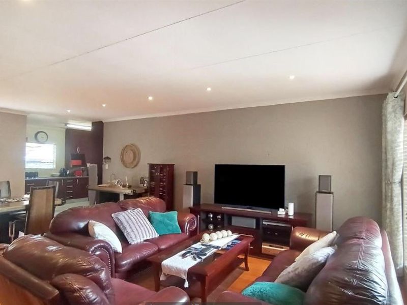 Spacious open-plan living and dining area featuring laminate flooring, recessed lighting, and direct access to outdoor space through sliding glass doors.