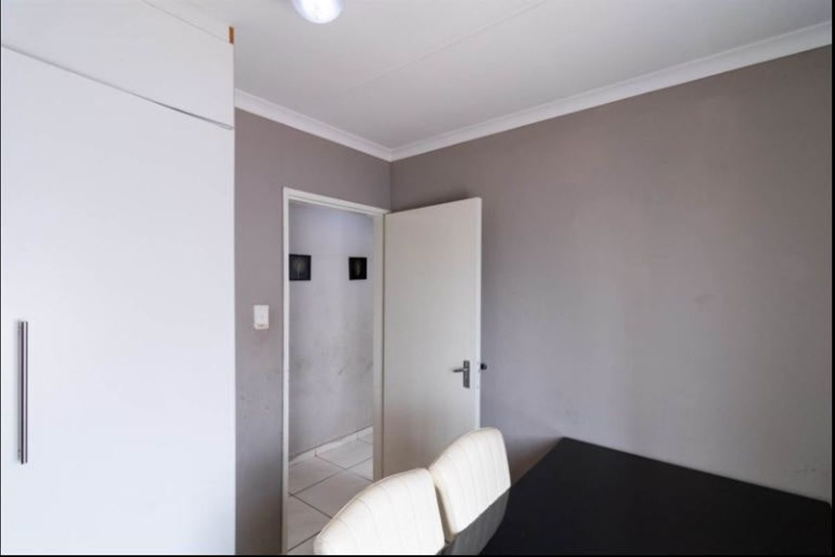A bedroom featuring a built-in wardrobe and neutral wall finishes, providing a functional space with potential for cosmetic updates.