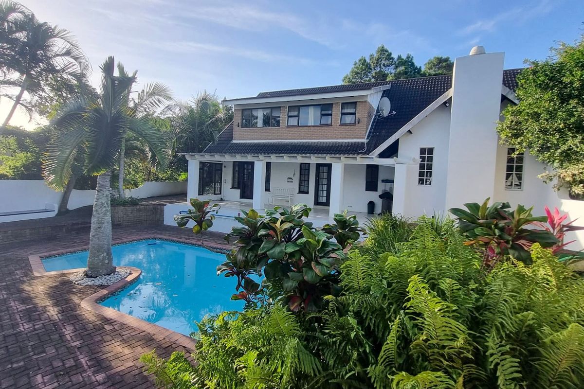 Rear view of the property featuring a swimming pool, brick paved patio area, and a well-maintained two-story building facade.