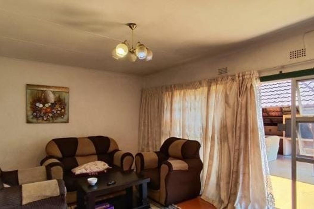 A living room featuring a sliding glass door providing access to an outdoor patio area.