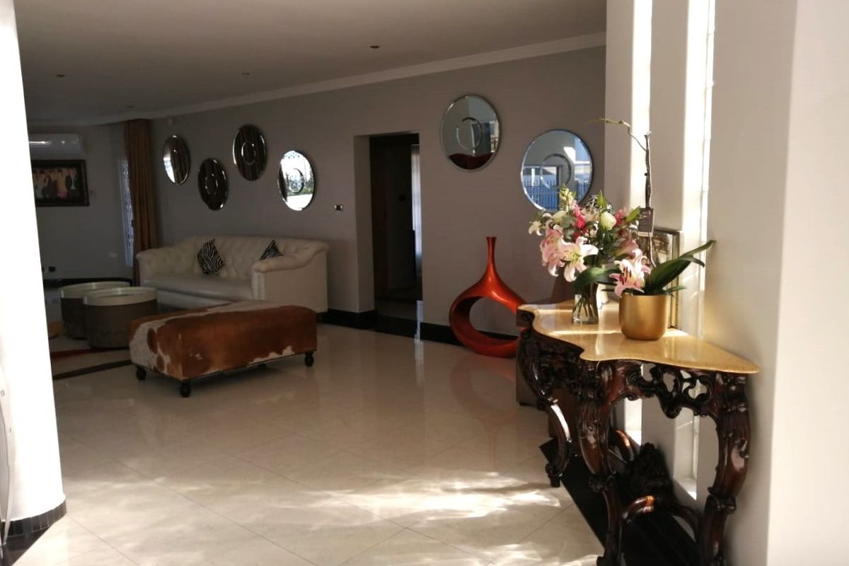 Spacious living area featuring polished tiled flooring and recessed downlighting, creating a bright and open atmosphere.