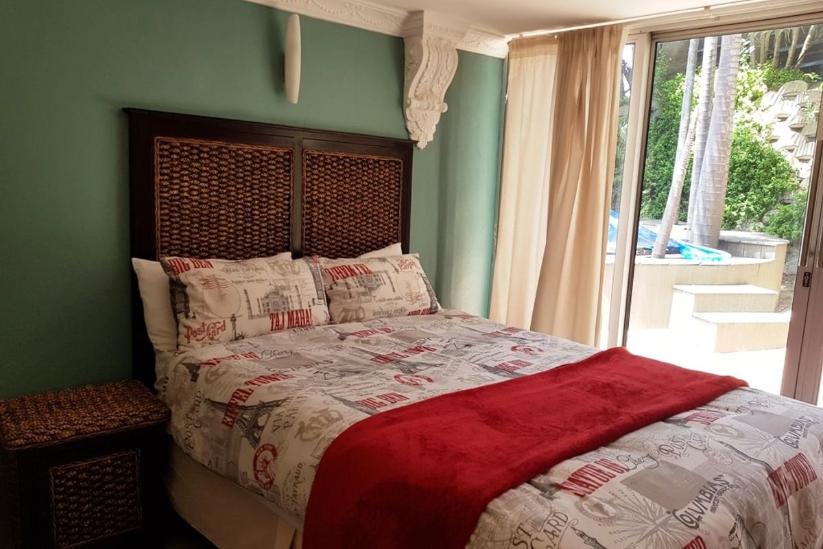 A bedroom featuring decorative ceiling cornices and corbels, with direct access to an outdoor patio area through large sliding glass doors.
