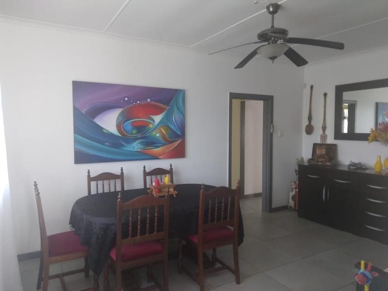 A dining room featuring tiled flooring and a ceiling fan, providing a functional space for meals.