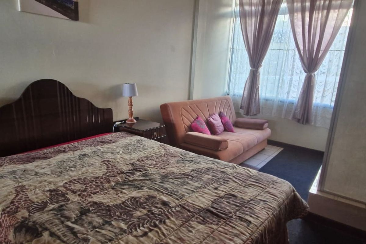 A bedroom featuring a large window providing natural light and a built-in wardrobe for storage.
