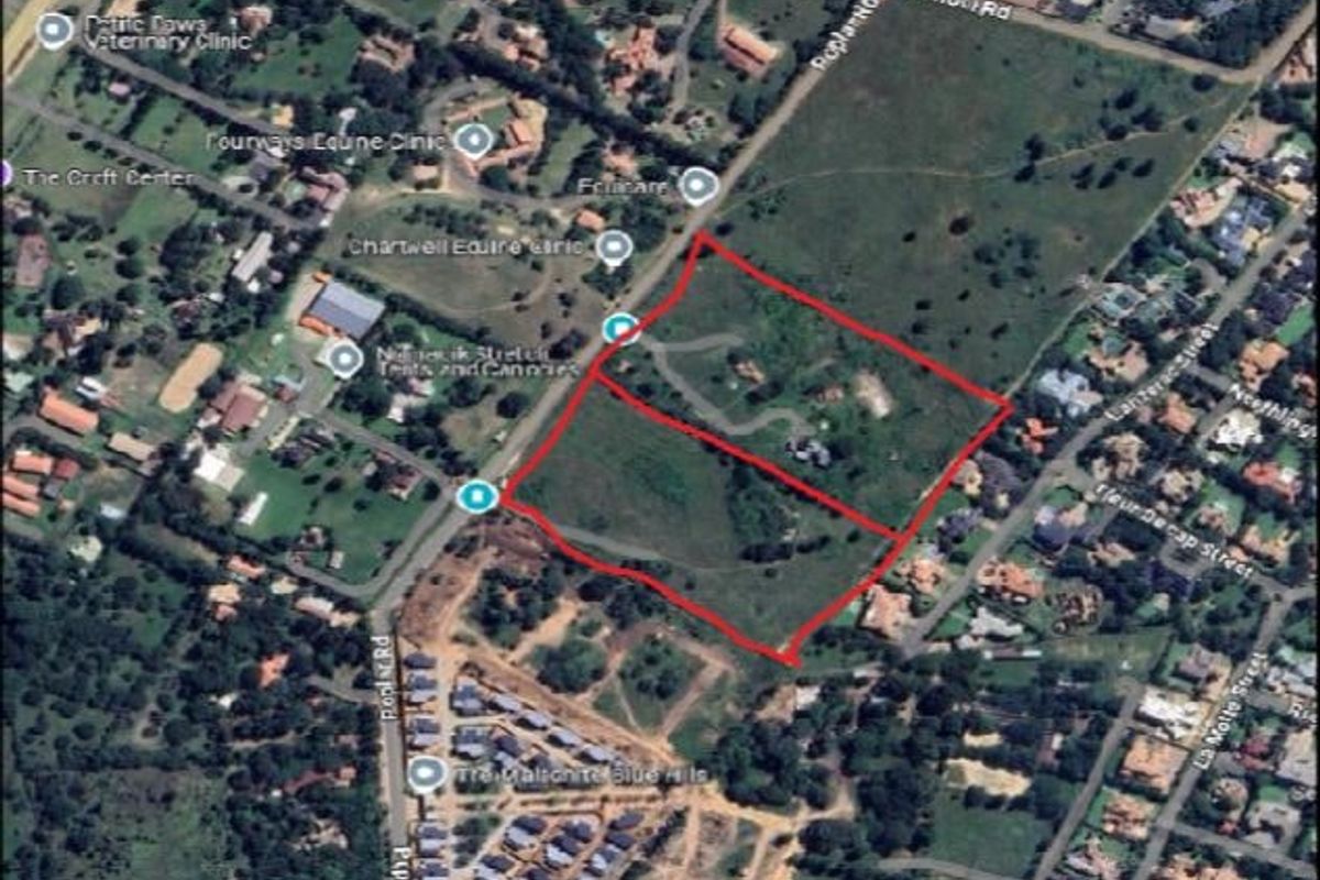 An aerial view showing the boundaries of a vacant residential land plot within a suburban neighborhood.