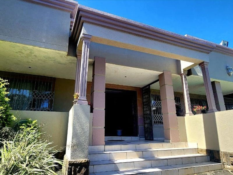 Front entrance of the house featuring a covered porch, stone cladding accents, and tiled steps leading to the main doorway.