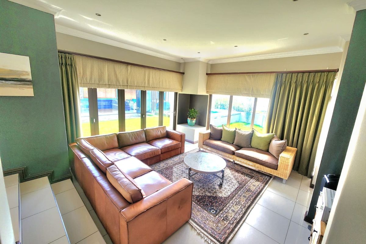Spacious living room featuring large sliding glass doors that provide natural light and direct access to the outdoor area, complemented by tiled flooring.