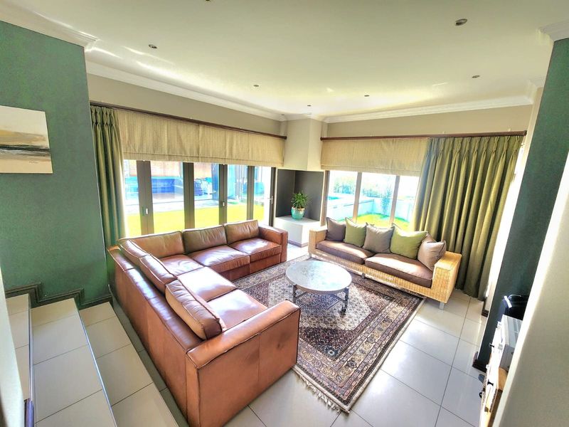 Spacious living room featuring large sliding glass doors that provide natural light and direct access to the outdoor area, complemented by tiled flooring.