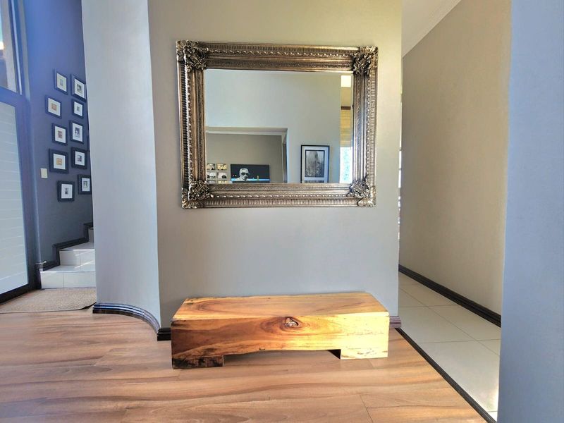 A well-maintained hallway featuring a blend of laminate and tiled flooring with a distinctive curved wall design.