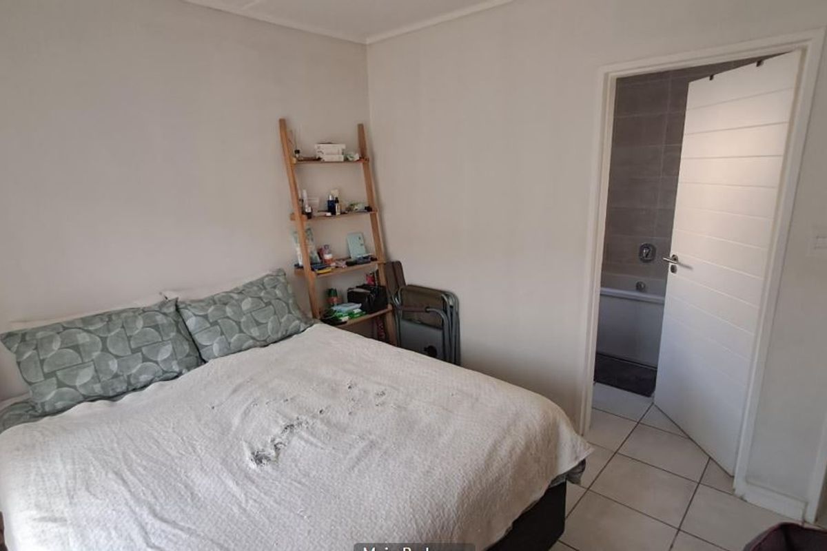A bedroom featuring tiled flooring and direct access to an en-suite bathroom through a white internal door.