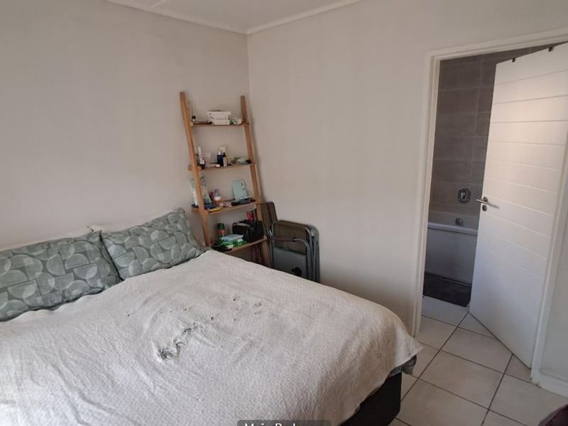 A bedroom featuring tiled flooring and direct access to an en-suite bathroom through a white internal door.