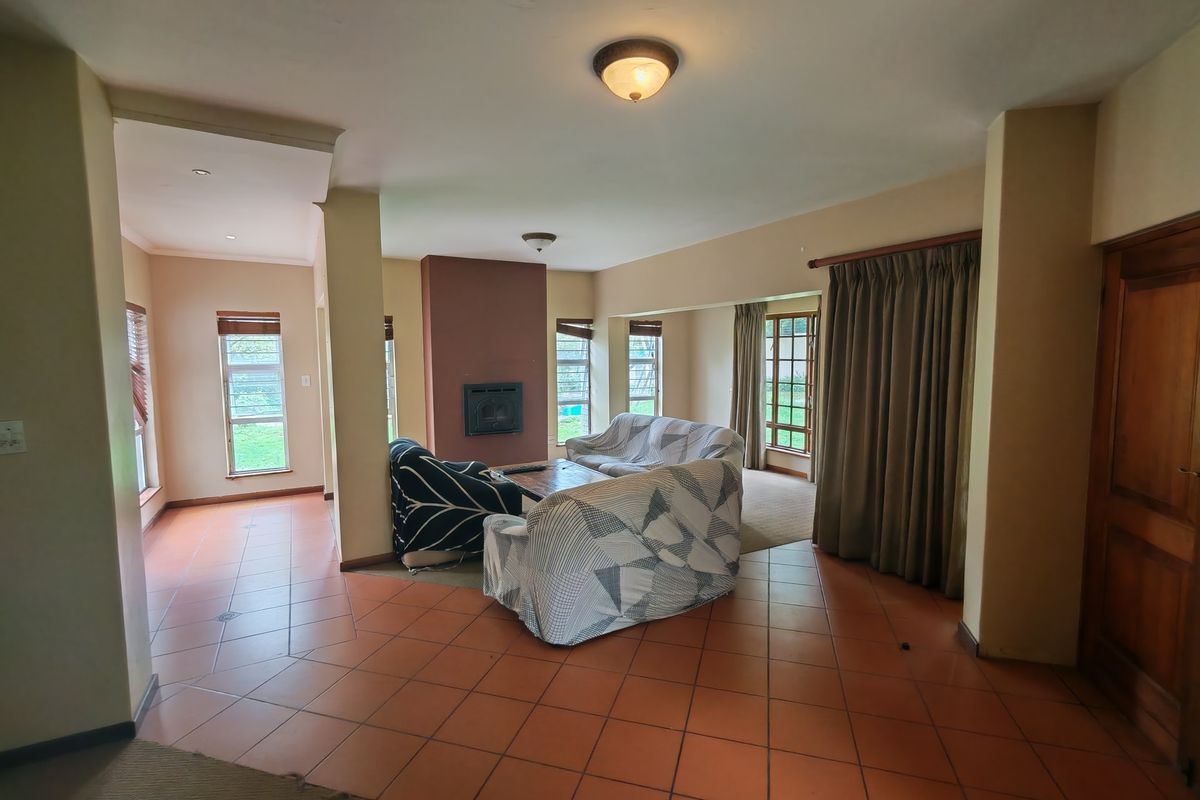 Spacious living area featuring tiled flooring, a built-in fireplace, and large windows allowing for natural light.