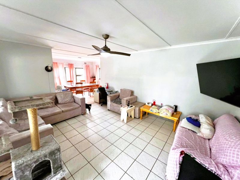 Open plan living and dining area featuring tiled flooring and a ceiling fan, providing a versatile space for family living.