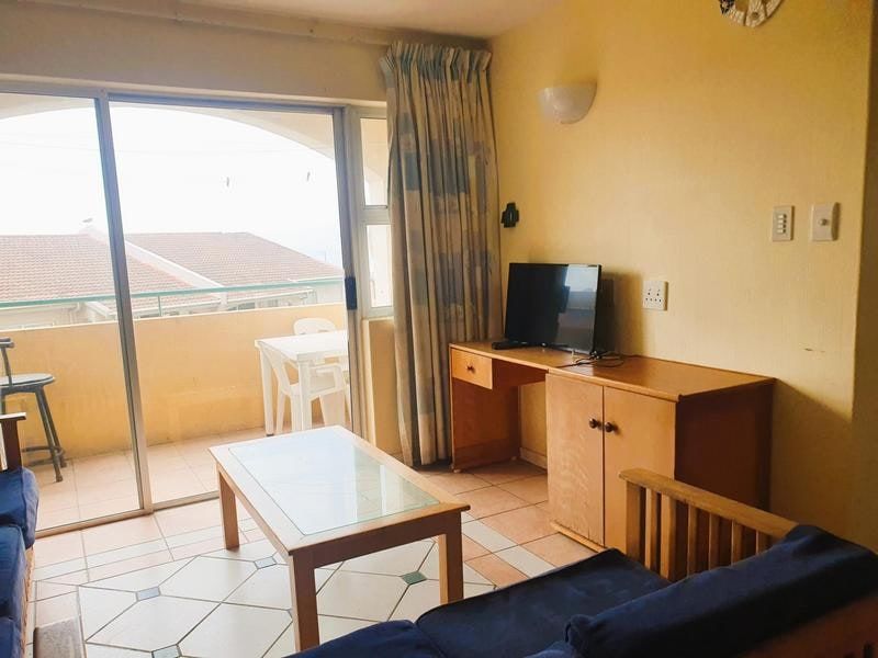Living area featuring tiled flooring and a large sliding glass door providing access to an outdoor balcony space.