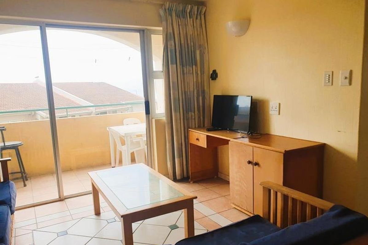 Living area featuring tiled flooring and a large sliding glass door providing access to an outdoor balcony space.
