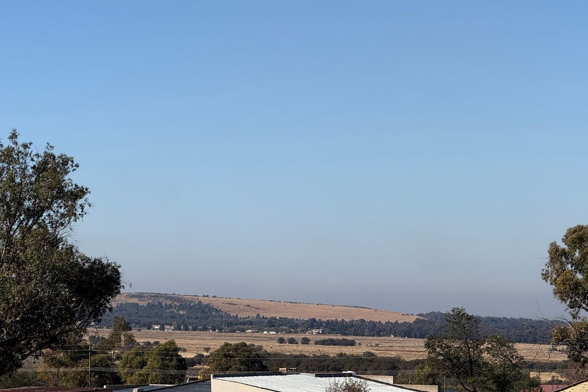 A scenic landscape view overlooking open fields and distant hills, showcasing the natural surroundings of the property.
