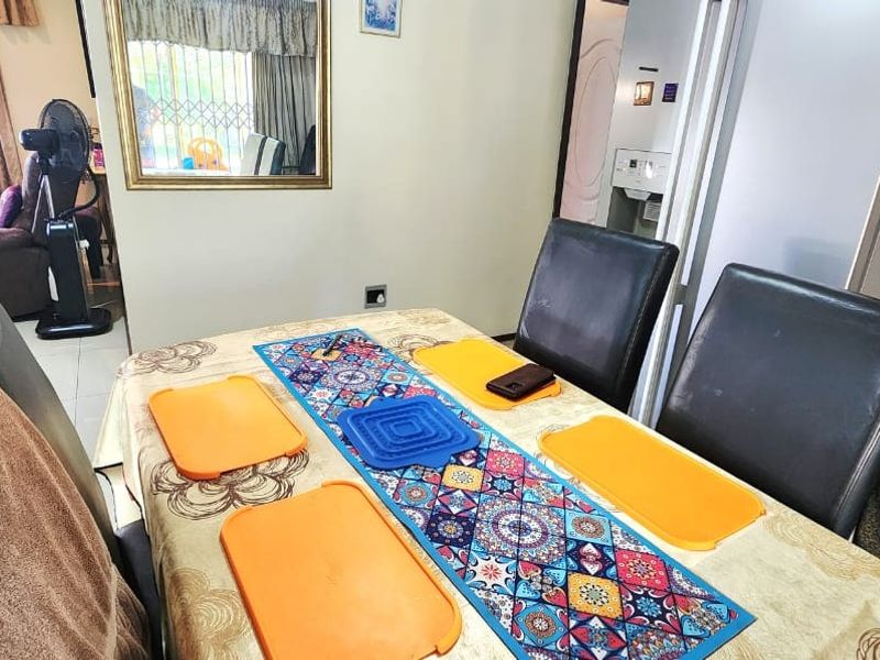 A functional dining area featuring tiled flooring and a wall-mounted mirror, providing a practical space for family meals.