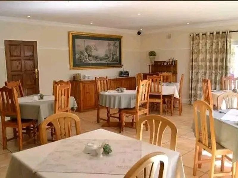 A spacious dining area featuring tiled flooring, recessed downlighting, and classic coving, suitable for hosting multiple tables.