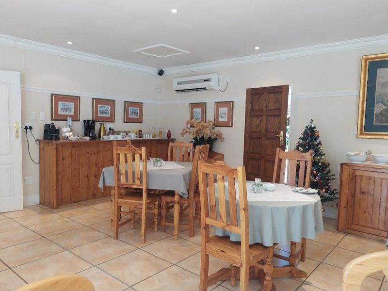 A dining area featuring tiled flooring, crown molding, and a wall-mounted split-system air conditioner.
