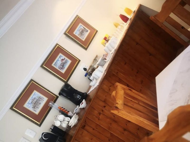A kitchen area featuring a timber-clad breakfast bar with integrated electrical outlets and decorative coving.