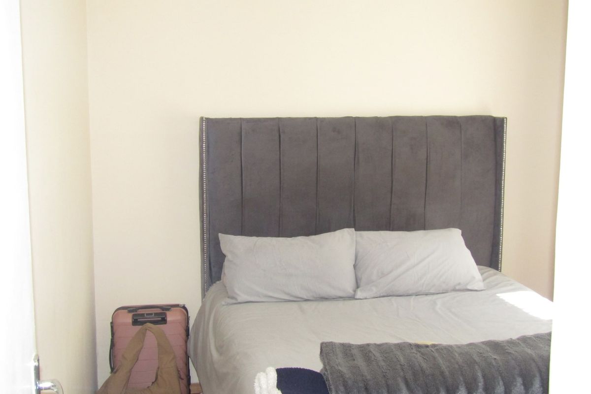 A compact bedroom space featuring neutral wall finishes.