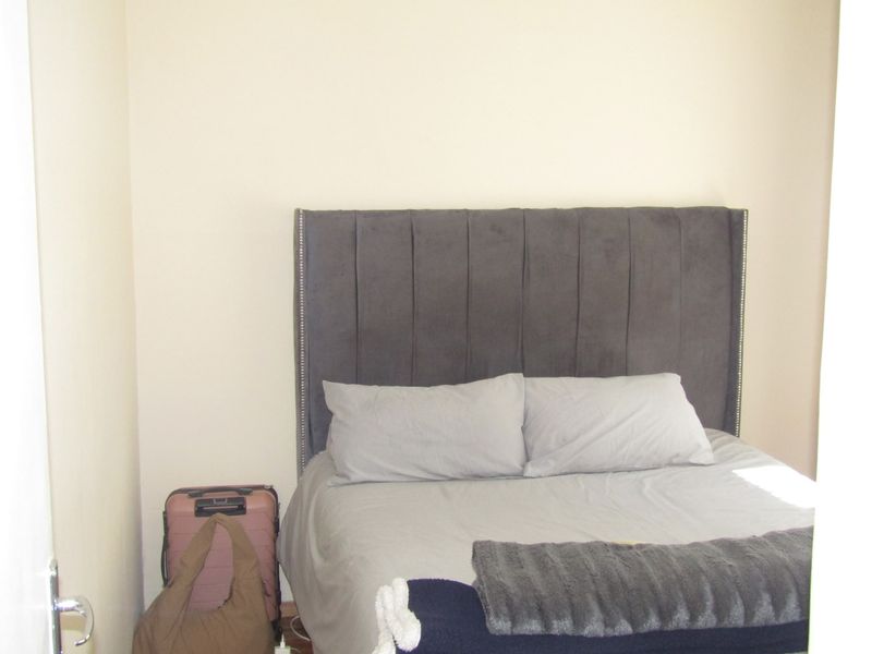 A compact bedroom space featuring neutral wall finishes.