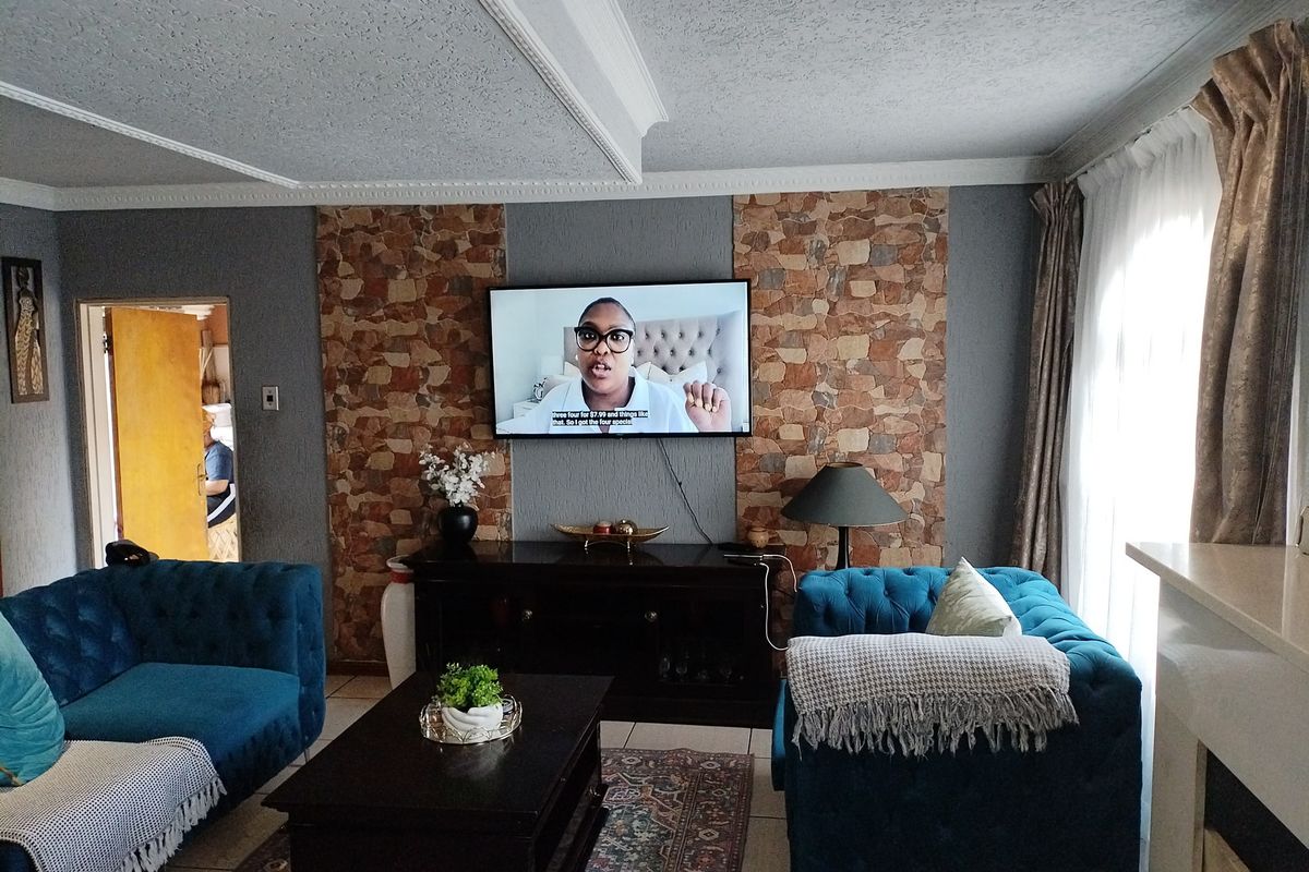 A living room featuring a stone accent wall, crown molding, and recessed ceiling lighting, providing a cozy space for relaxation.