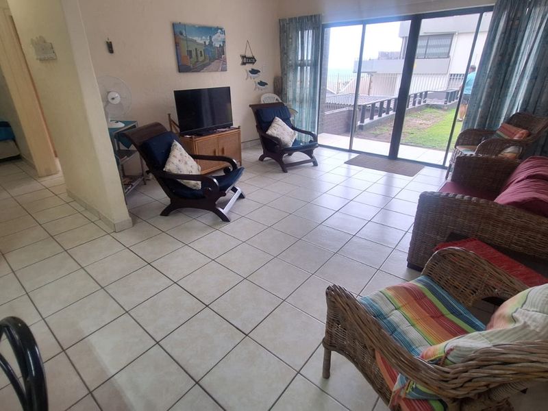 Spacious living room featuring neutral tiled flooring and large sliding glass doors that provide access to the outdoor area.