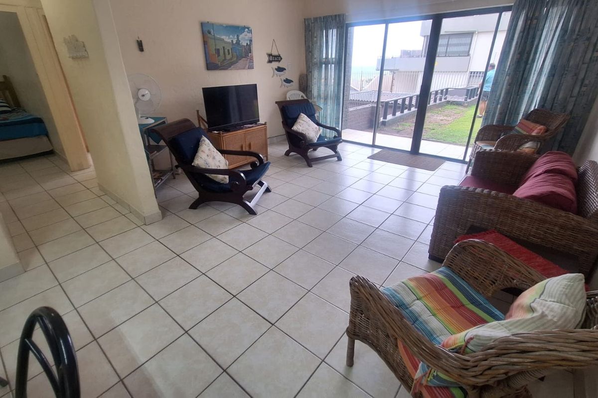 Spacious living room featuring neutral tiled flooring and large sliding glass doors that provide access to the outdoor area.