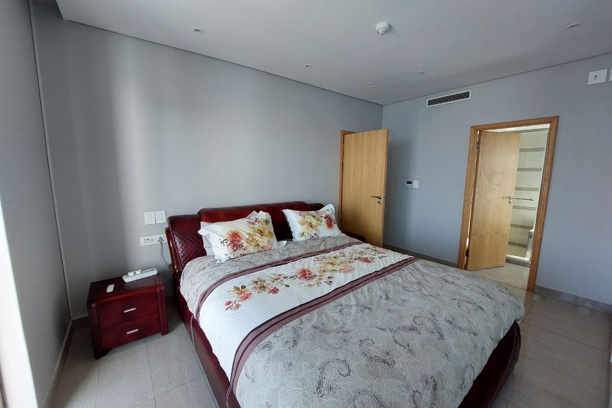 A well-maintained bedroom featuring neutral grey walls, tiled flooring, recessed ceiling lighting, and integrated ducted air conditioning.