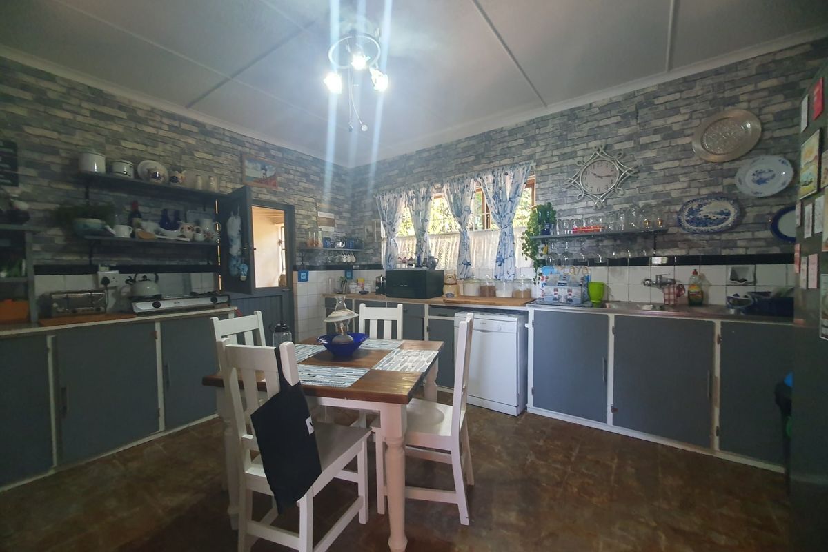 A functional kitchen featuring built-in cabinetry, a tiled backsplash, and integrated appliances, offering a practical layout with potential for modern updates.