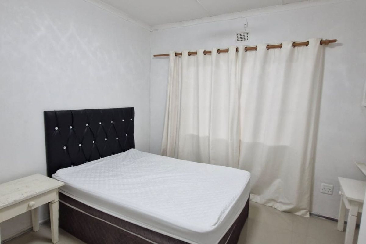 A functional bedroom featuring tiled flooring, built-in shelving, and neutral wall finishes, providing a blank canvas for personalization.