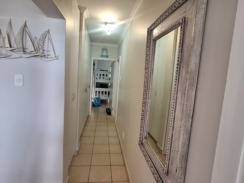 A functional hallway featuring tiled flooring and built-in storage cupboards, providing access to adjacent rooms within the apartment.