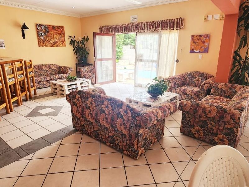 A commercial bar area featuring a built-in counter, ceramic tiled flooring, and sliding glass doors providing access to the outdoor pool area.