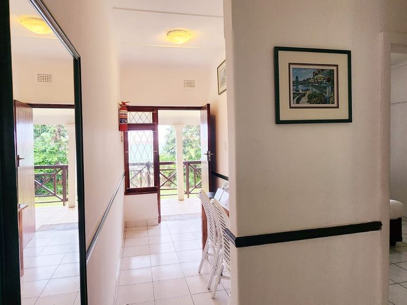 A bright hallway featuring tiled flooring and access to an outdoor patio area, connecting to adjacent rooms within the home.