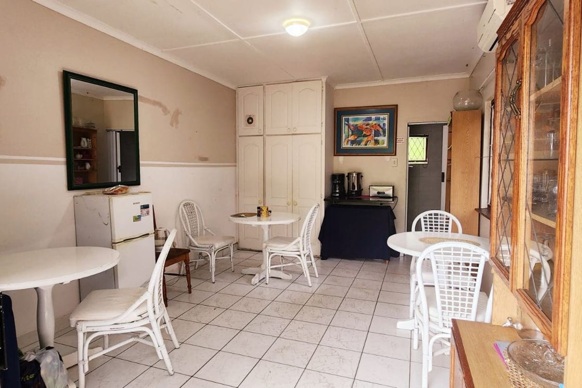 Living area featuring tiled flooring, built-in storage cupboards, and an air conditioning unit, showing signs of wear on the walls.